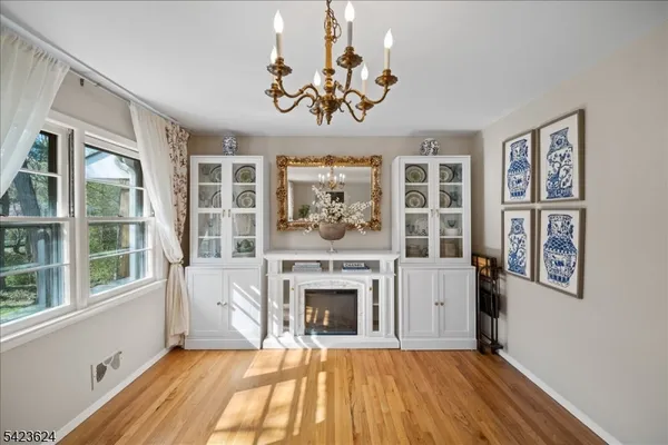 a view of a livingroom with a fireplace wooden floor and windows