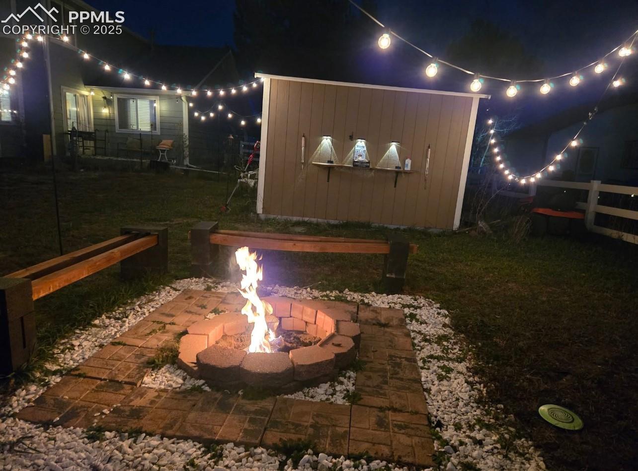 7660 Bullet Road Peyton, CO 80831 - Photo 36 of 50 Yard at night featuring a patio area and a lawn