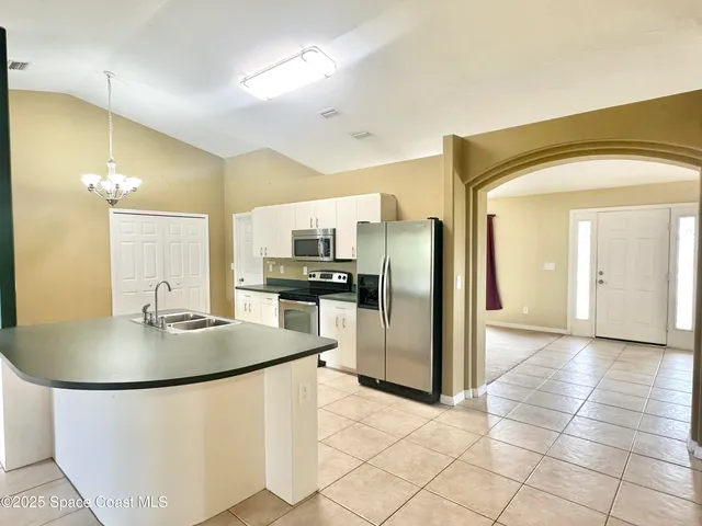 a kitchen with stainless steel appliances granite countertop a sink and a white cabinets