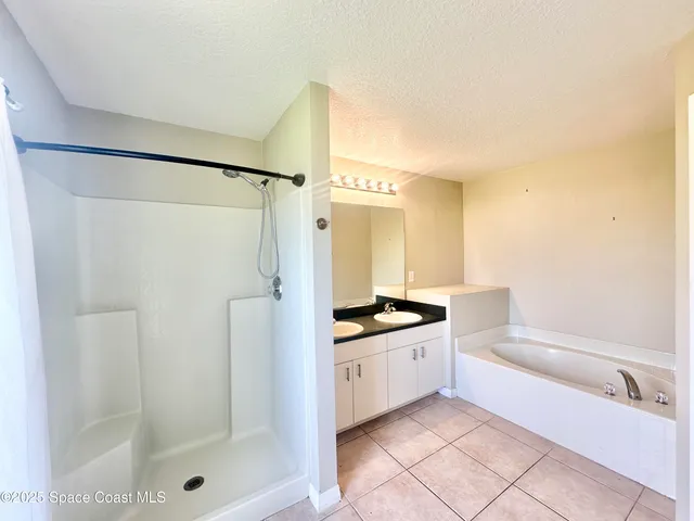 a bathroom with a granite countertop sink a toilet a mirror and shower