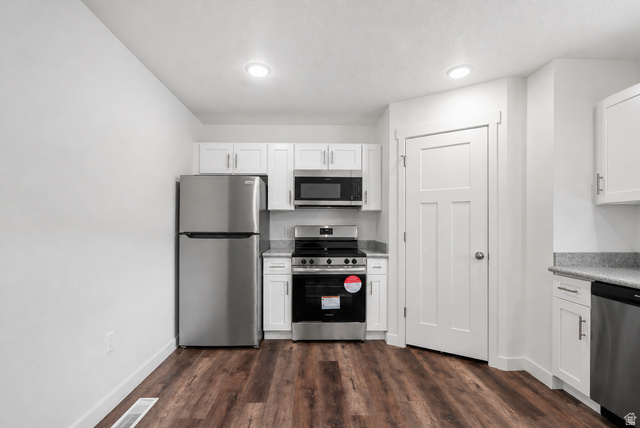 449 West 980th South Ogden, UT 84404 - Photo 7 of 23 Kitchen featuring wood-finish flooring, white shaker cabinetry, stainless steel appliances, and a light-colored countertop