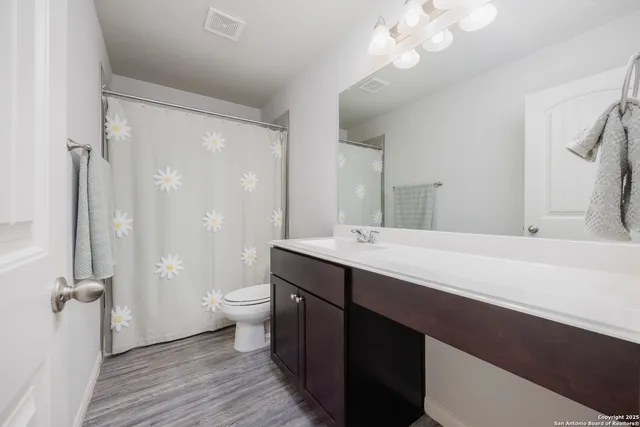 a bathroom with a double vanity sink toilet mirror and shower