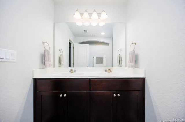 a bathroom with double sink and a mirror