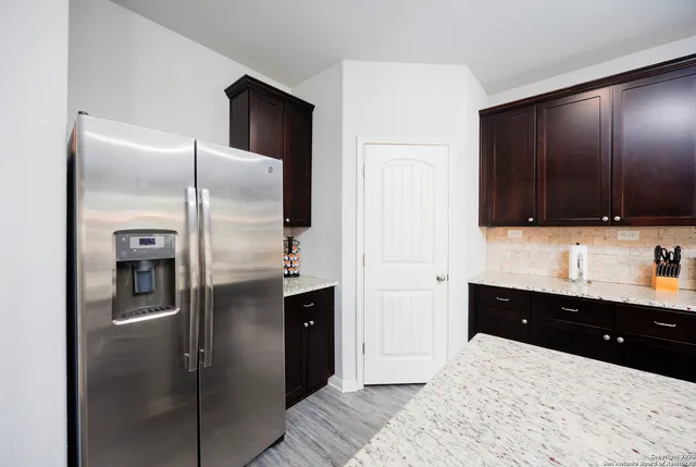 a kitchen with granite countertop a refrigerator and a sink