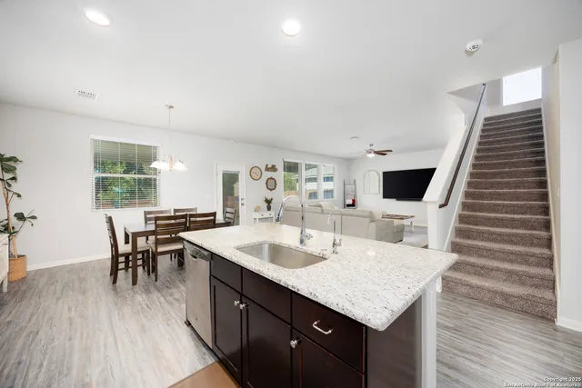 a kitchen with a sink and chairs