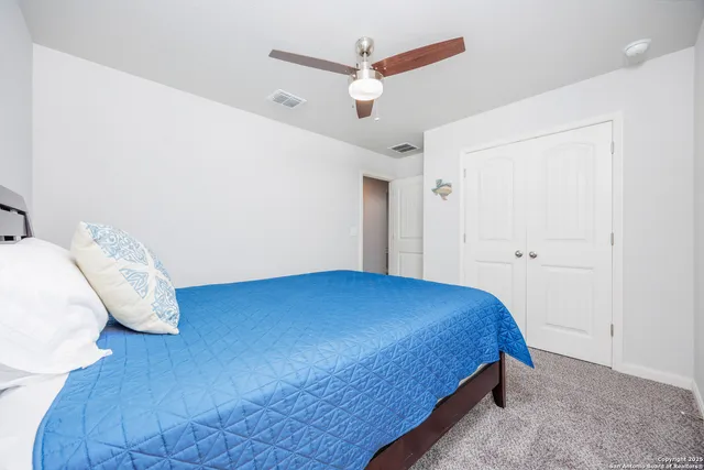 a bedroom with a bed and a ceiling fan