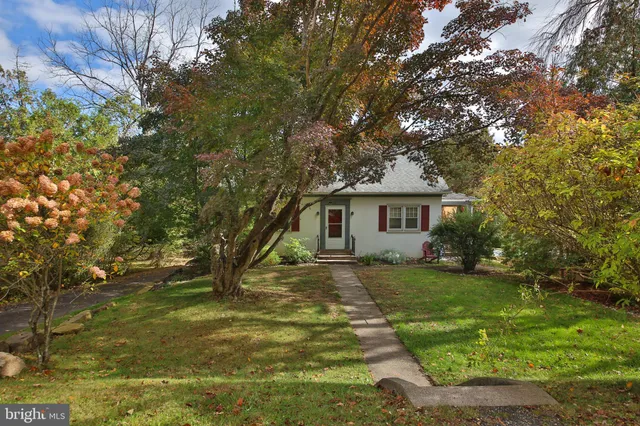 a view of a yard in front of a house with large trees