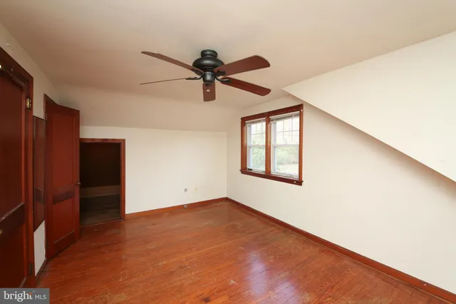 an empty room with wooden floor and closet