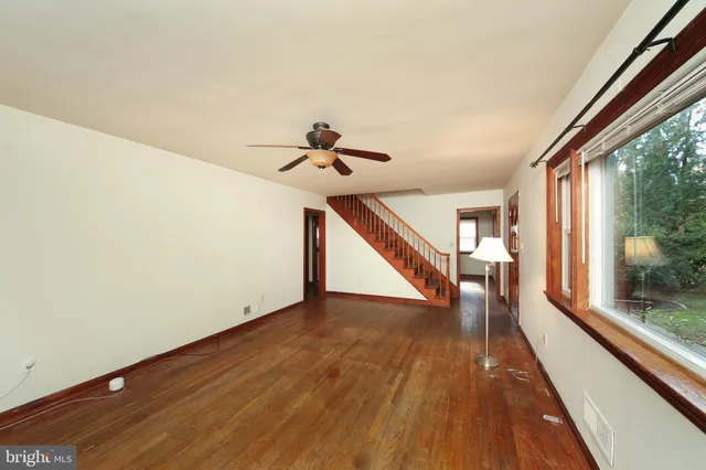 a view of a hallway with wooden floor and staircase