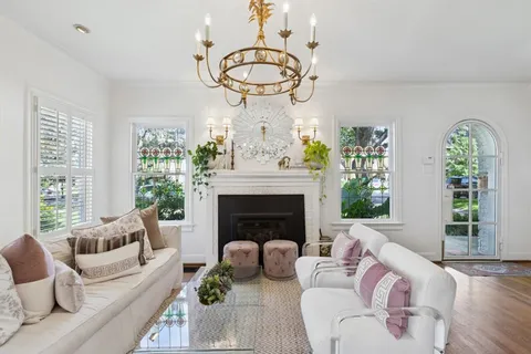 a living room with furniture a fireplace and a large window