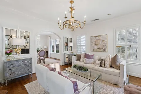 a living room with furniture chandelier and a window
