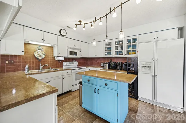 a kitchen with stainless steel appliances granite countertop a sink and a refrigerator