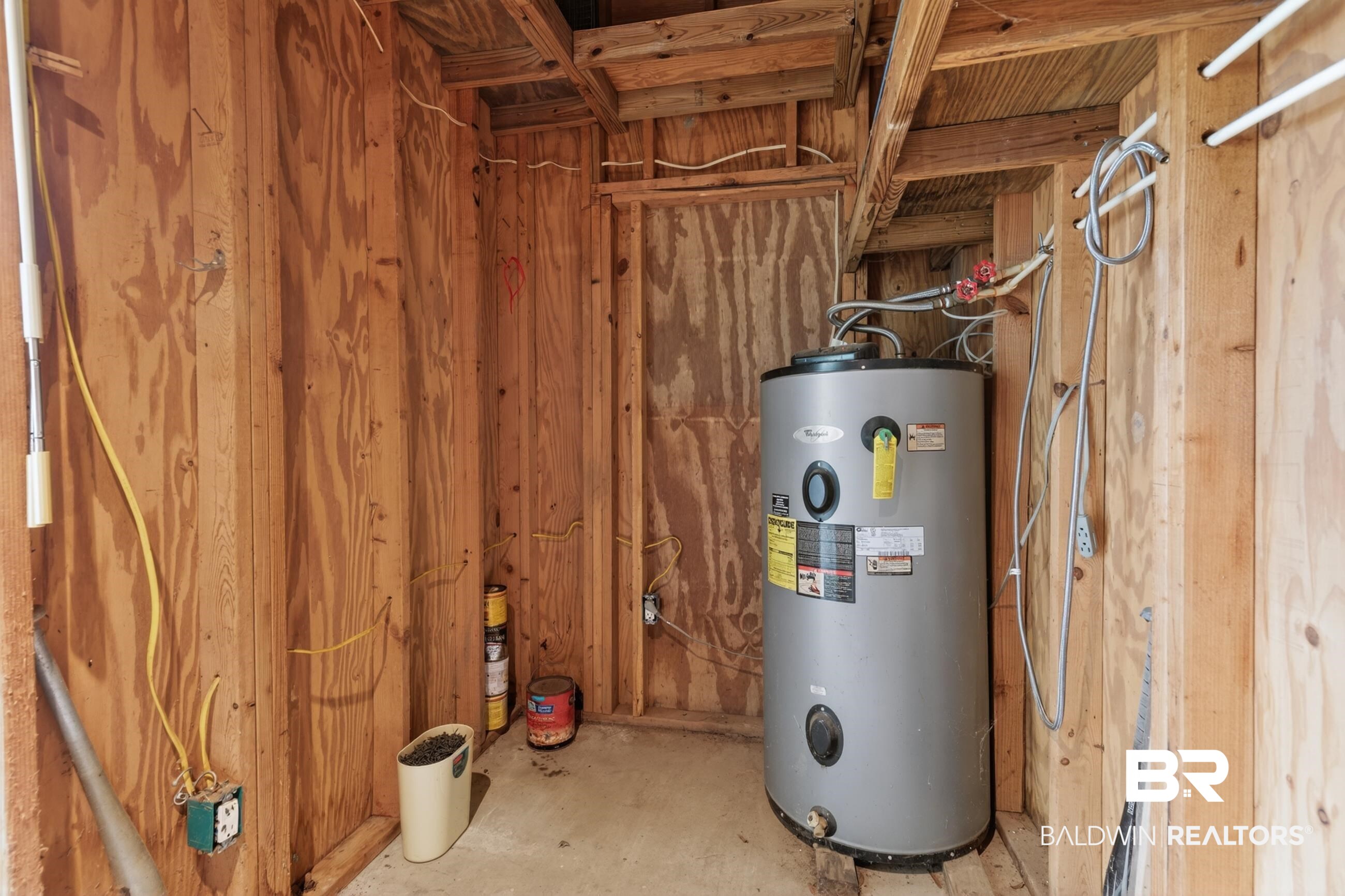 24903 Patterson Road Robertsdale, AL 36567 - Photo 25 of 57 Water heater installation within a utility space featuring exposed wood framing and plywood walls