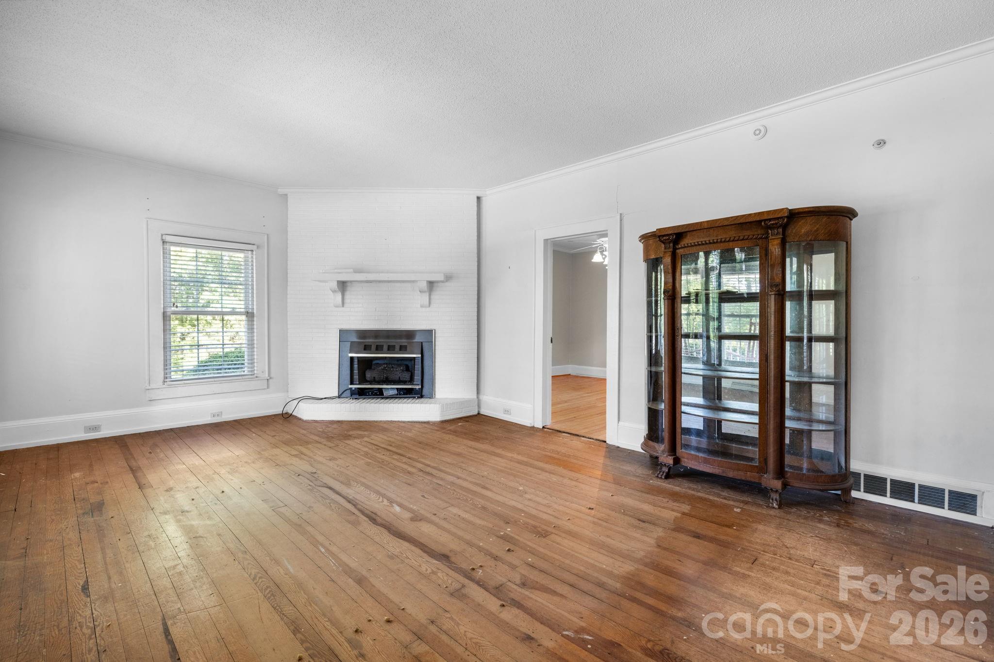 144 Hunter Bridge Road Stony Point, NC 28678 - Photo 15 of 45 an empty room with windows fireplace and wooden floor