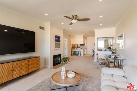 a living room with furniture kitchen view and a flat screen tv