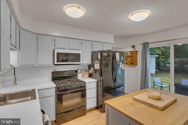 a kitchen with granite countertop a refrigerator stove and sink