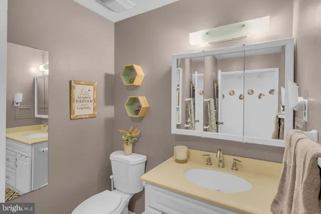 a bathroom with a granite countertop toilet sink and mirror