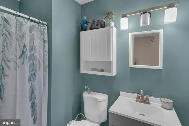 a bathroom with a sink toilet and mirror