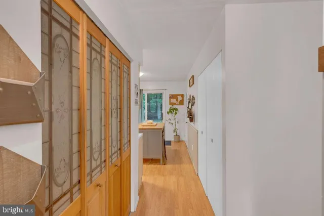 a view of a hallway with wooden floor and dining room