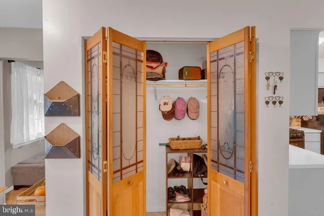 a view of a hallway with a refrigerator and cabinets