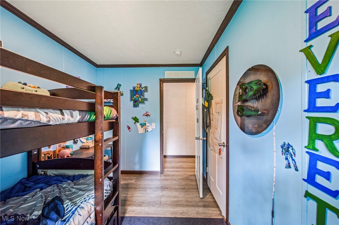202 West Main Road, Unit LOT 13 Conneaut, OH 44030 - Photo 16 of 23 Bedroom with crown molding, wood finished floors, and a textured ceiling