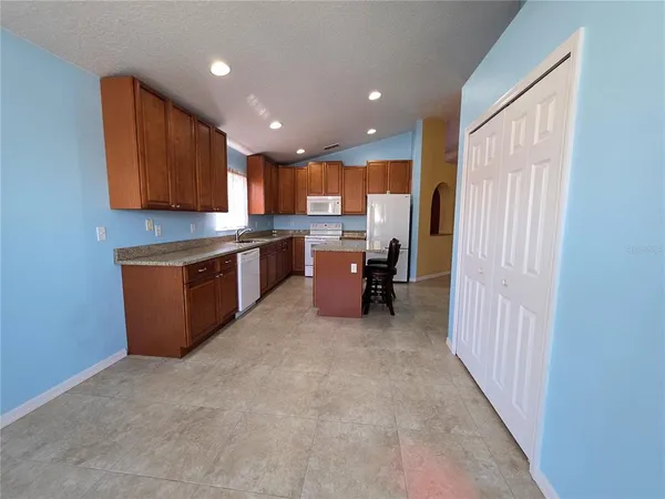 a kitchen with a sink a counter top space stainless steel appliances and cabinets