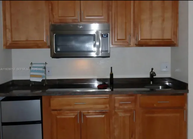 a kitchen with granite countertop a sink and a stove