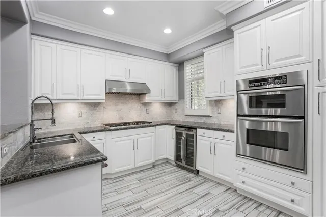 a kitchen with granite countertop a stove sink and cabinets