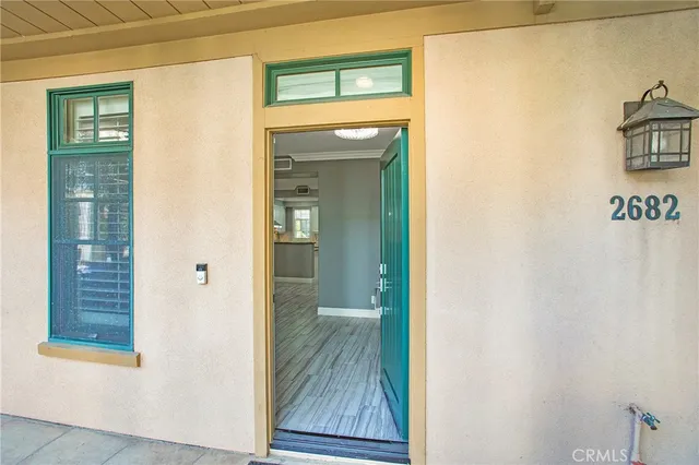 a view of a hallway with wooden floor and a bathroom