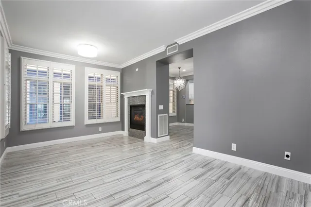 a view of empty room with wooden floor and fireplace