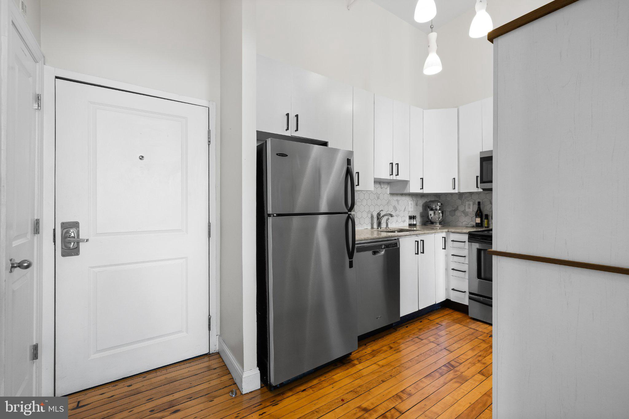 511 South Bond Street, Unit 302 Baltimore, MD 21231 - Photo 4 of 24 a kitchen with a refrigerator a sink and cabinets
