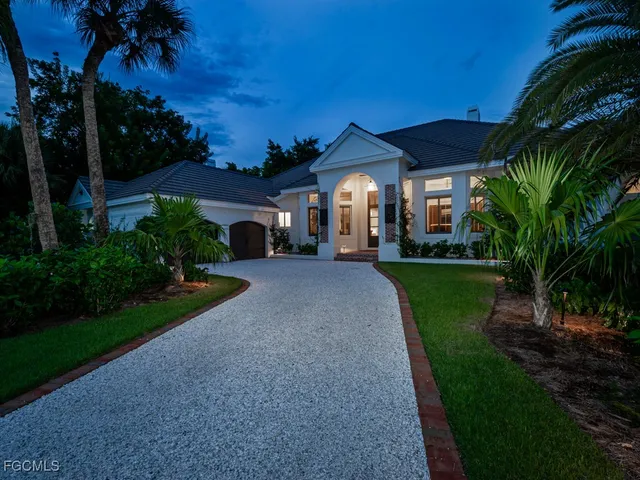 a front view of a house with a yard and potted plants