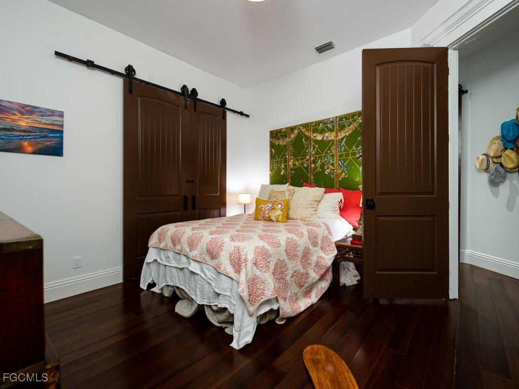 2388 Wulfert Road Sanibel, FL 33957 - Photo 25 of 49 a bedroom with a bed and wooden floor