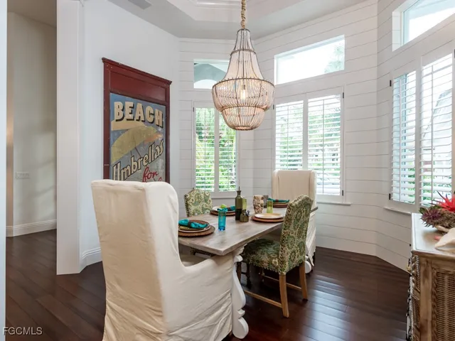 a dining room with furniture a chandelier and wooden floor