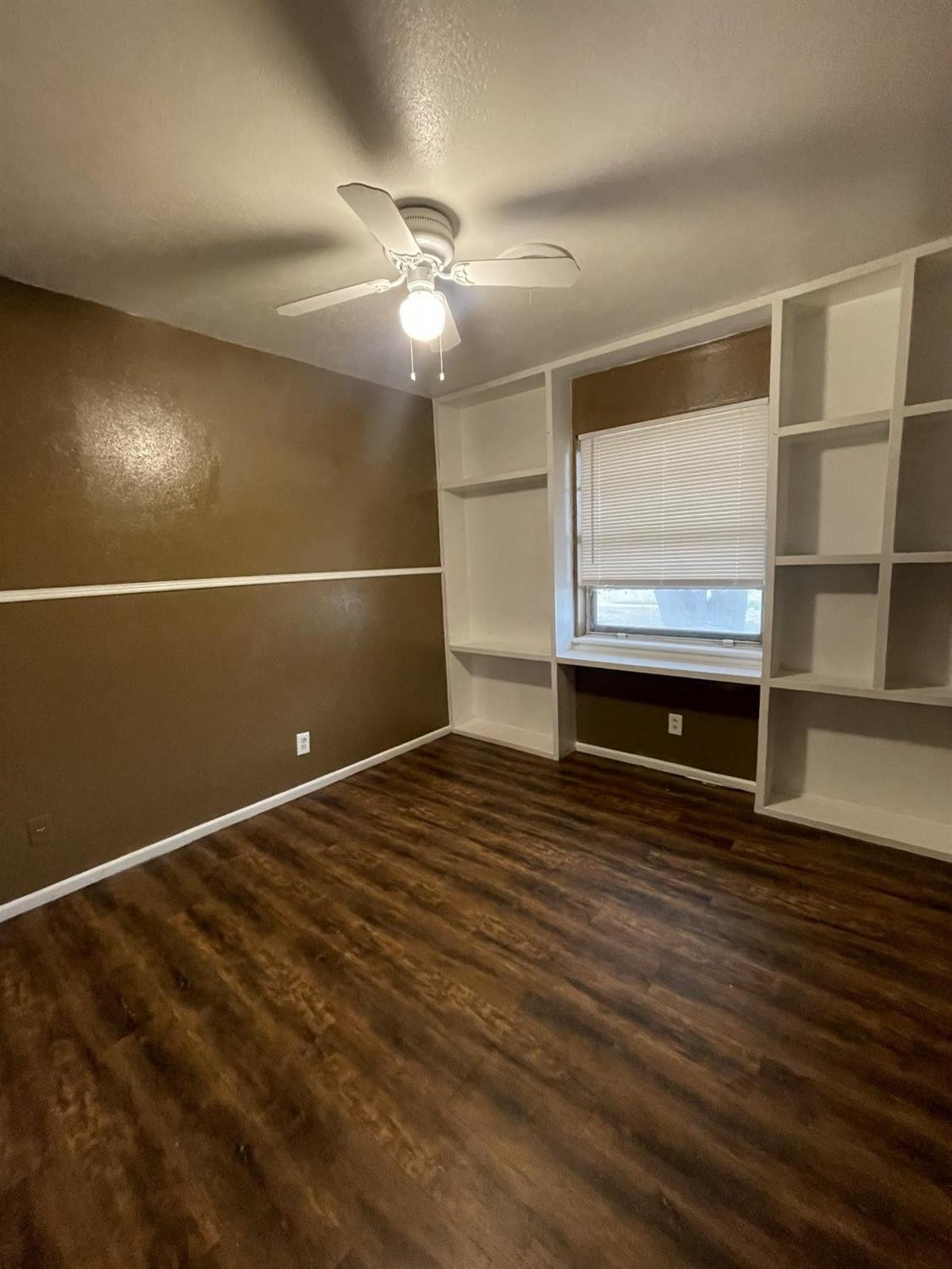 5424 45th Street Lubbock, TX 79414 - Photo 12 of 16 en empty room with wooden floor and ceiling fan