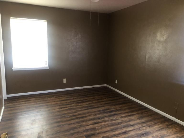 5424 45th Street Lubbock, TX 79414 - Photo 13 of 16 an empty room with wooden floor and windows