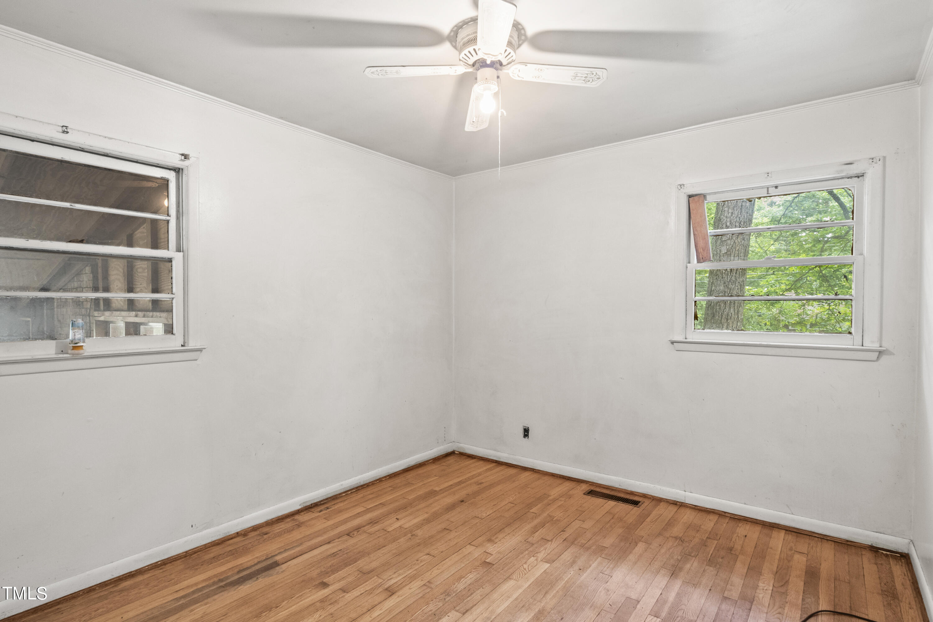 633 Ashford Street Raleigh, NC 27610 - Photo 18 of 25 an empty room with a window and wooden floor