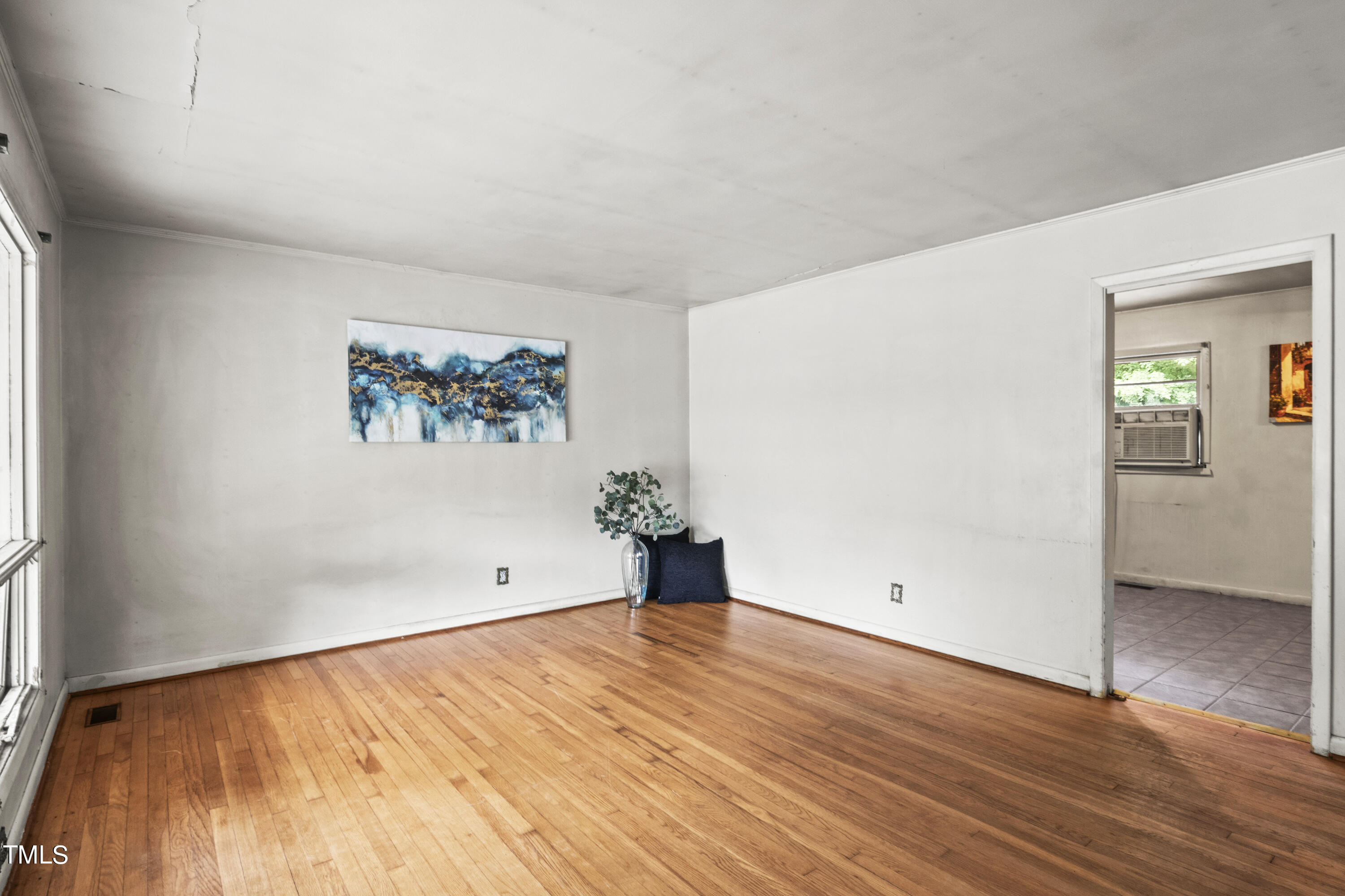 633 Ashford Street Raleigh, NC 27610 - Photo 6 of 25 an empty room with wooden floor and windows
