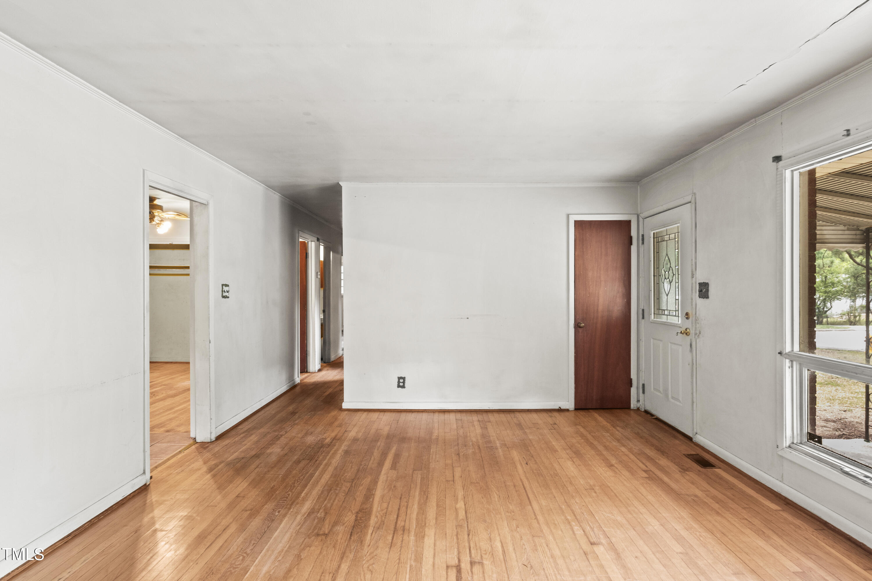 633 Ashford Street Raleigh, NC 27610 - Photo 7 of 25 an empty room with wooden floor and windows