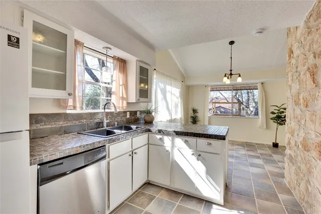 a kitchen with granite countertop a sink and a stove top oven