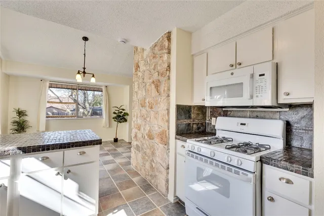 a kitchen with a sink stove and cabinets