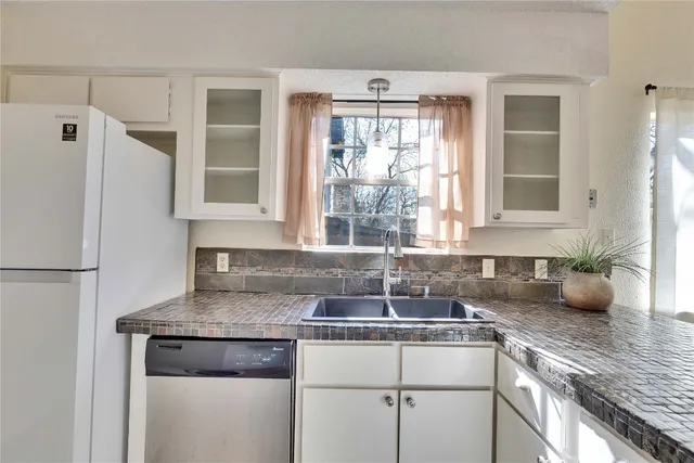 a kitchen with white cabinets and appliances