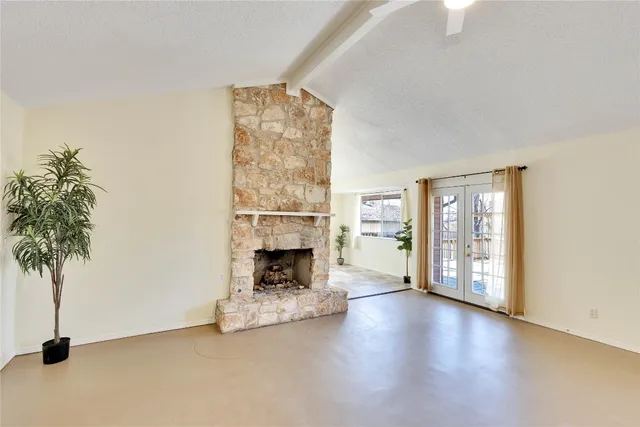 a view of an empty room with a window and fireplace