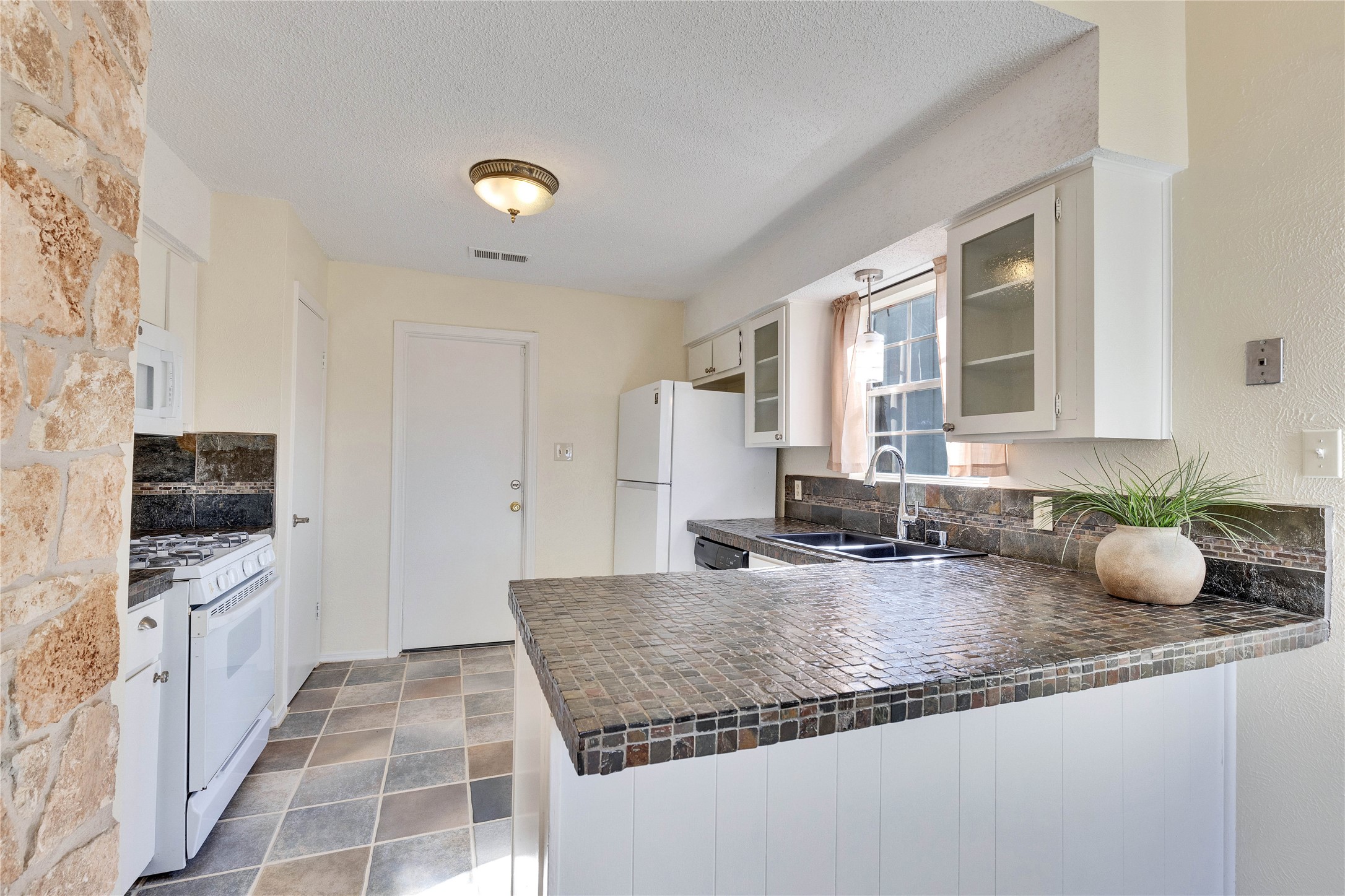 1002 Bodark Lane Austin, TX 78745 - Photo 9 of 35 a kitchen with granite countertop a sink and a stove top oven