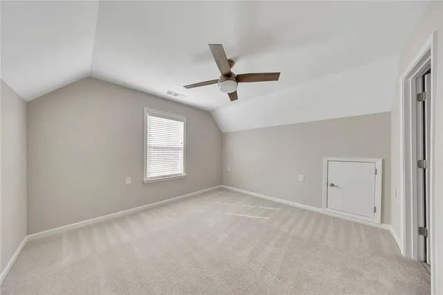an empty room with closet and a ceiling fan