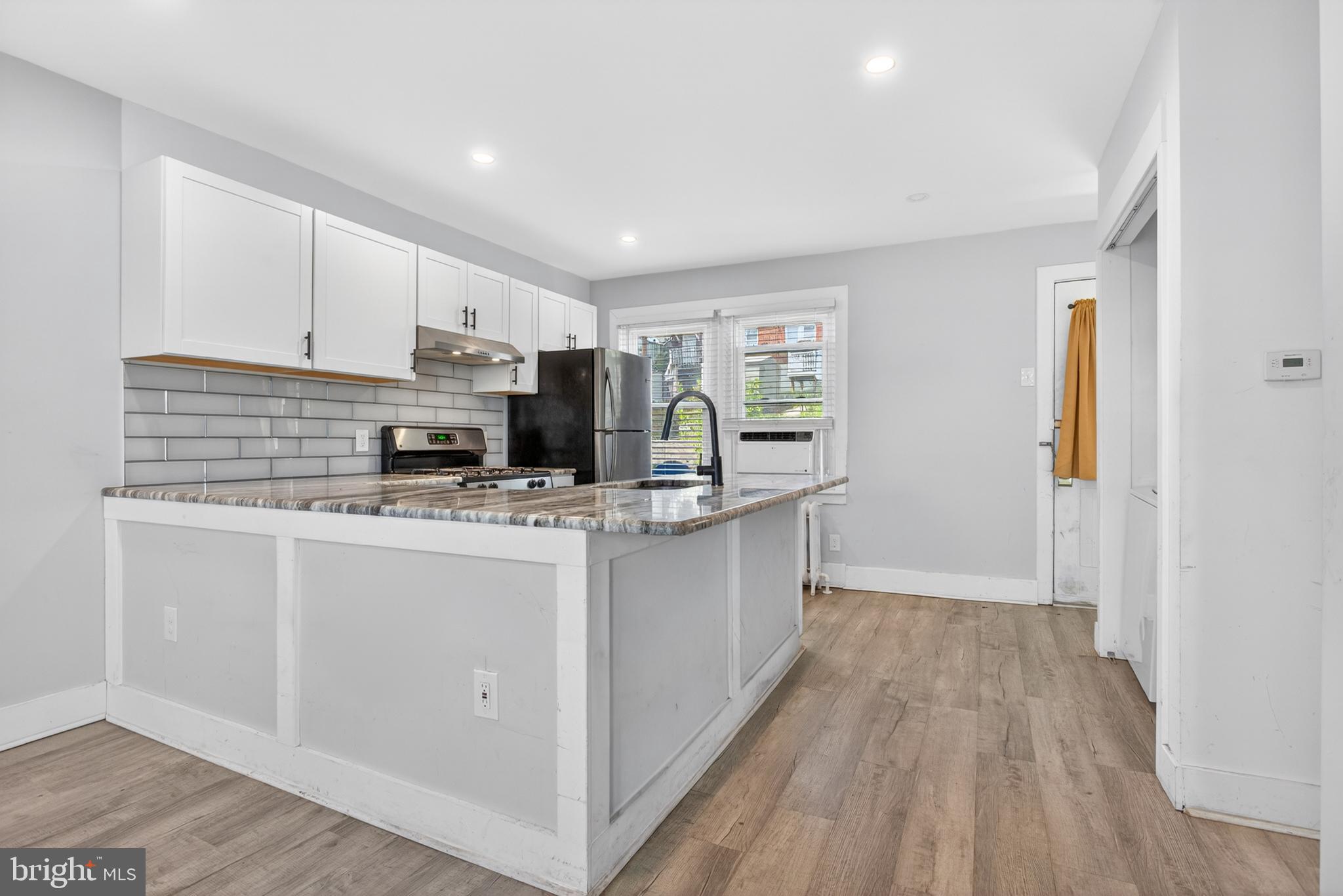 1122 West Ridge Road Marcus Hook, PA 19061 - Photo 12 of 27 a kitchen with kitchen island granite countertop a sink cabinets and wooden floor