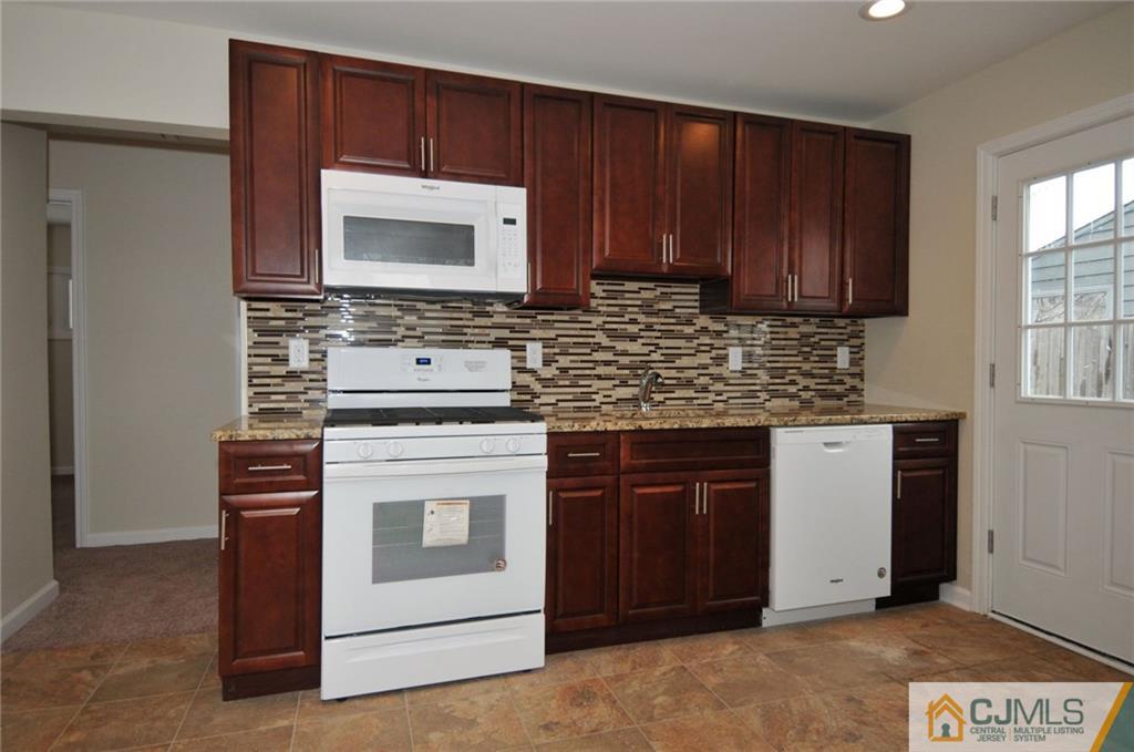 26 Cambridge Road Edison, NJ 08817 - Photo 2 of 17 a kitchen with stainless steel appliances wooden cabinets and a stove top oven