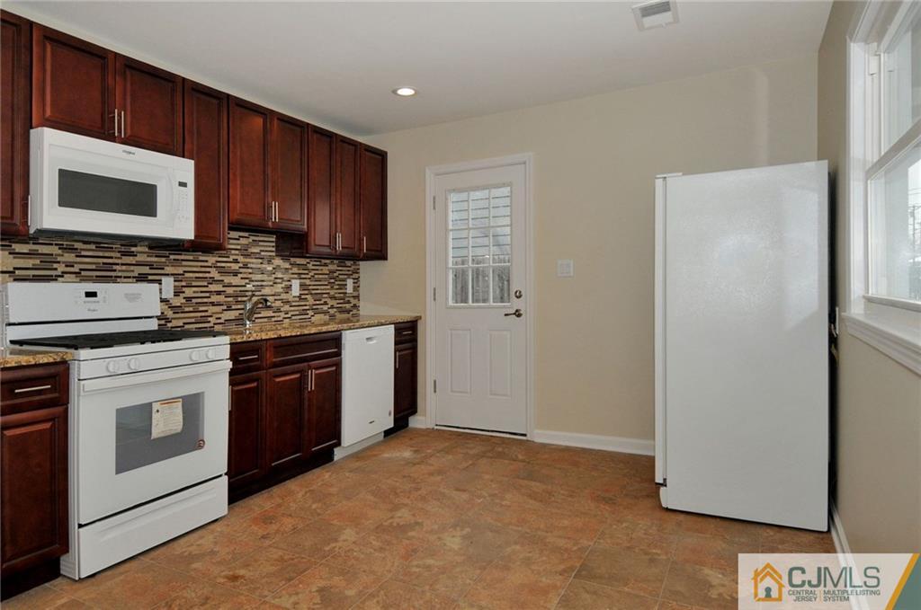 26 Cambridge Road Edison, NJ 08817 - Photo 3 of 17 a kitchen with stainless steel appliances granite countertop a stove top oven a sink and a microwave