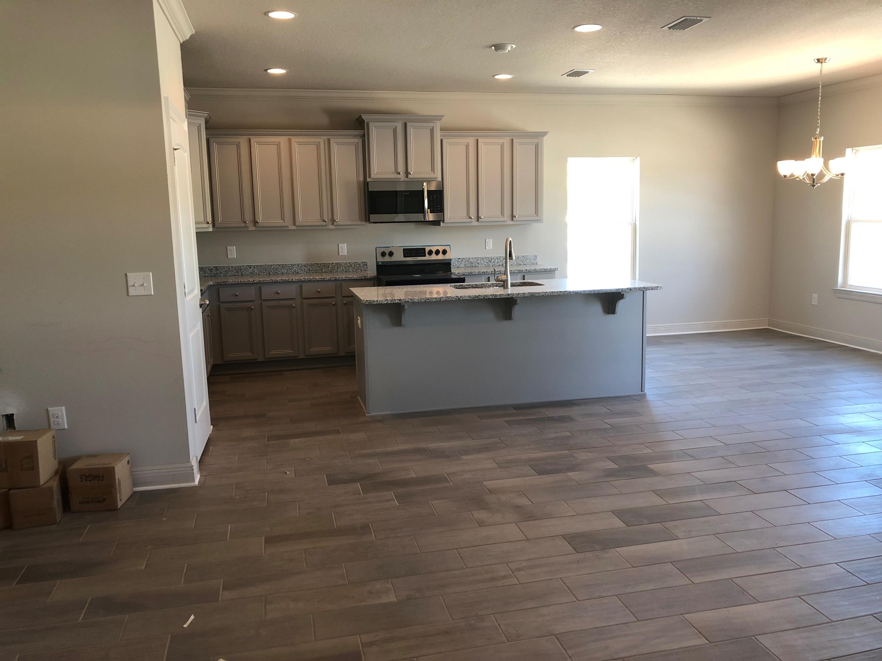 87 Wayne Trail Santa Rosa Beach, FL 32459 - Photo 3 of 11 a kitchen with kitchen island granite countertop a sink cabinets and stainless steel appliances