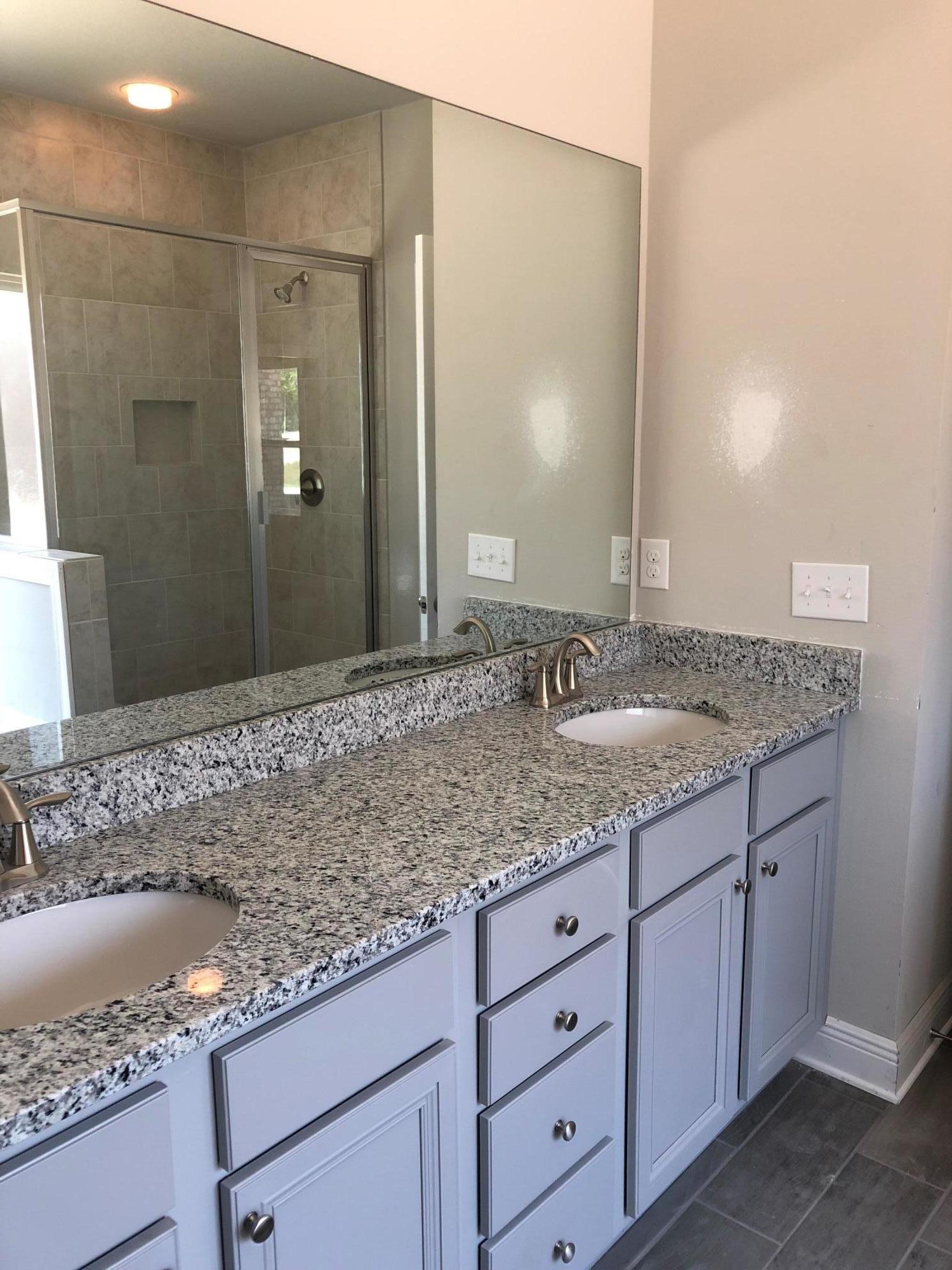 87 Wayne Trail Santa Rosa Beach, FL 32459 - Photo 4 of 11 a bathroom with a granite countertop sink and a mirror
